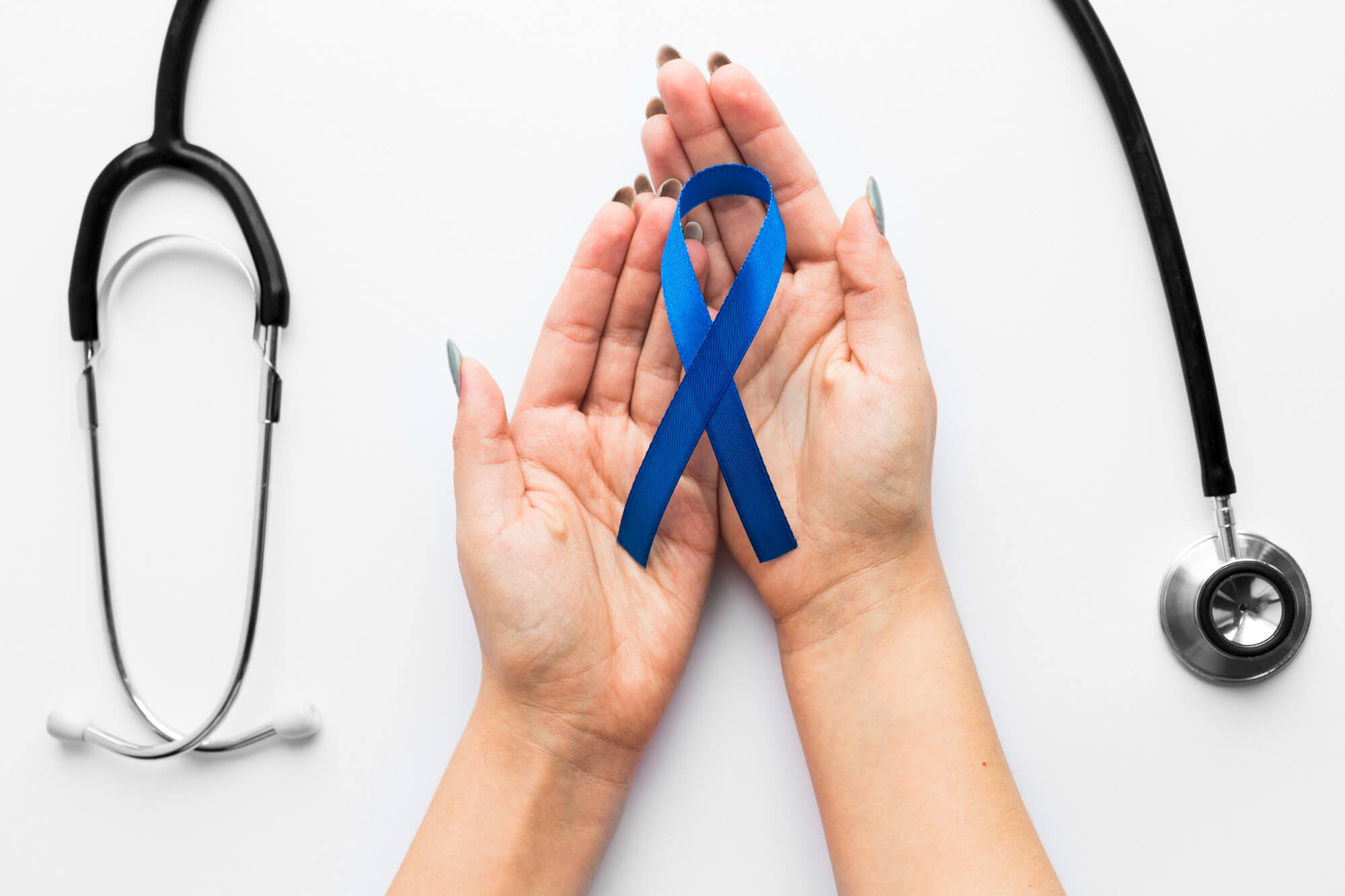 hand holding a blue ribbon symbolizing cancer