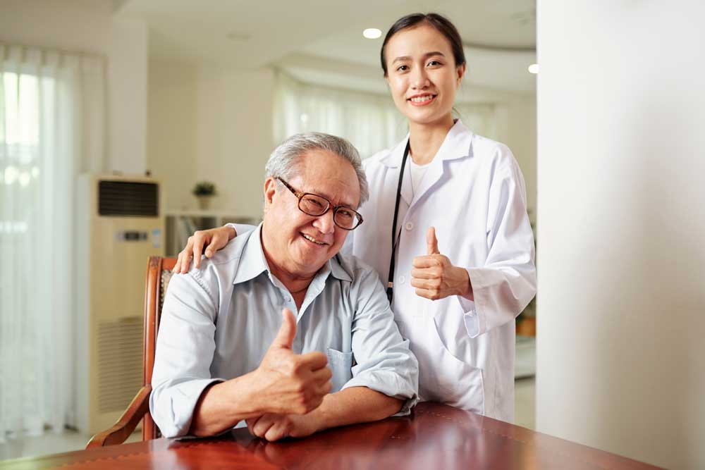 doctor and patient giving the thumbs up sign