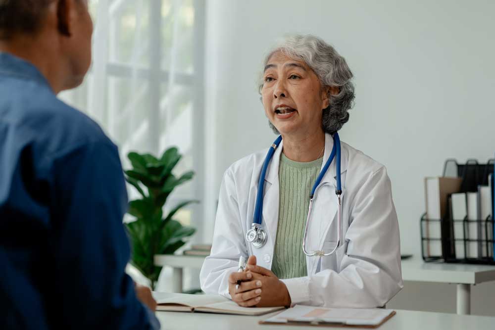 elderly doctor speaking with a male patient