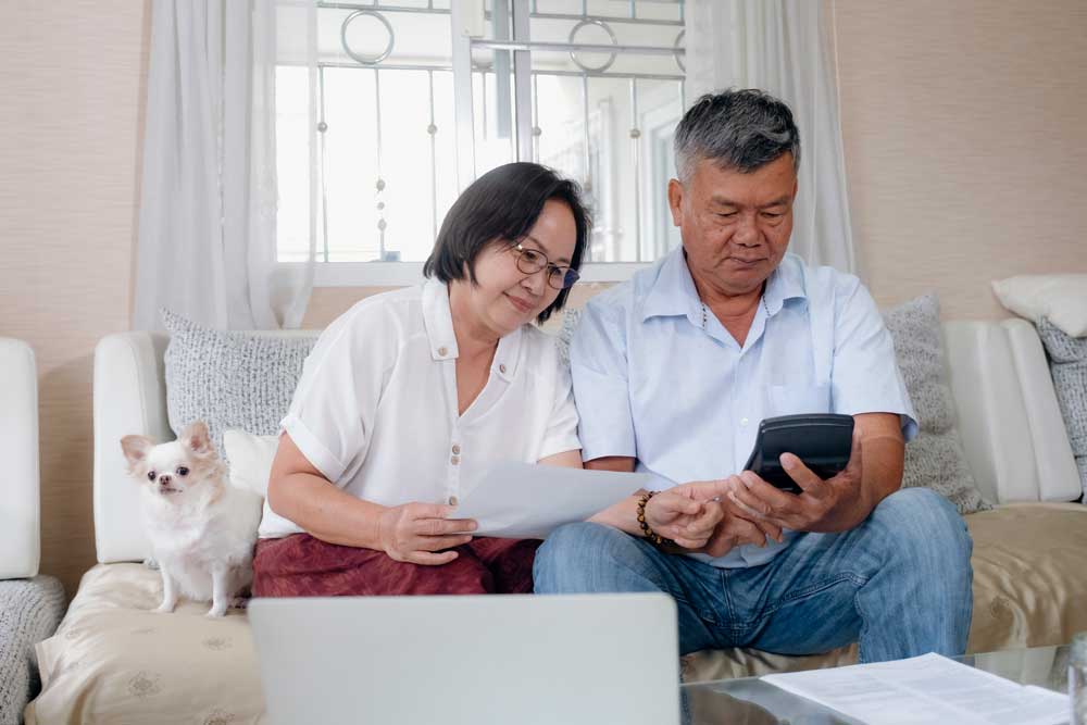 elderly couple and their dog looking at some papers