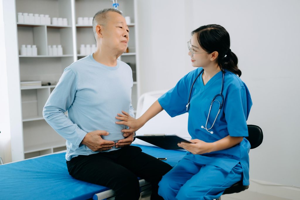 healthcare worker examining an elderly male patient